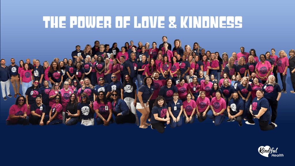 Group photo of the Kindful Health team wearing navy and pink shirts that say the power of love and kindness.